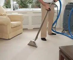 Carpet cleaning professional removing dirt and stains with a hot-water extraction tool in a home, Philadelphia, PA.