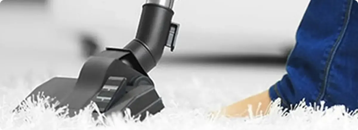 Close-up of a professional vacuuming a white carpet in Gloucester City.